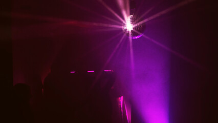 Party atmosphere with disco ball. Light beams reflecting from a disco ball. Nightlife concept....