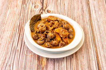 Popular Spanish snail stew with chorizo recipe served in a tapas restaurant