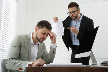 Boss scolding employee in office. Toxic work environment