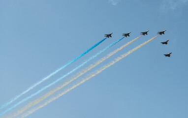 Group of aircrafts  flying with color smoke in blue sky under the Kiev during the parade on the occasion of 30 years of independence of Ukraine, august 2021