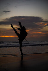 Fototapeta premium silhouette of a person dancing on the beach at sunset