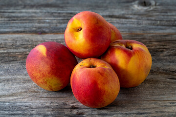 Fototapeta na wymiar Vivid peaches and nectarines on wood floor