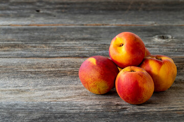 Vivid peaches and nectarines on wood background. Copy space
