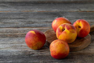 Fototapeta na wymiar Vivid peaches and nectarines on wood floor