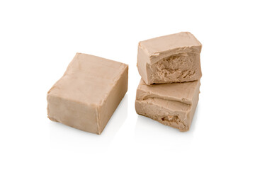 Fresh yeast cubes, one brewer's yeast whole and another cut in half isolated on white background