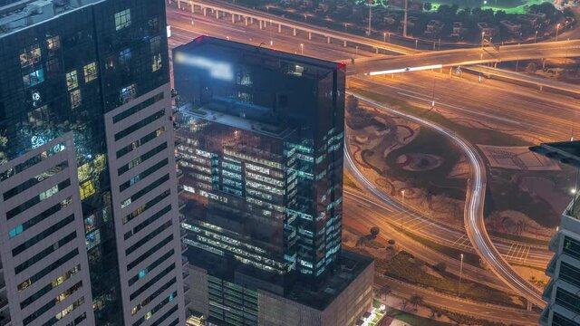 Crossroad junction between golf course and Dubai Marina intersected by Sheikh Zayed Road aerial night timelapse.