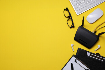 Flat lay composition with modern Wi-Fi router on yellow background, space for text