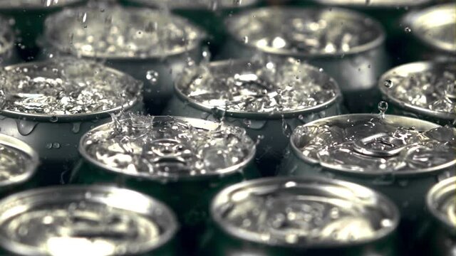 Super slow motion on tins with beer drop drops of water with spray. Macro background. Filmed on a high-speed camera at 1000 fps.