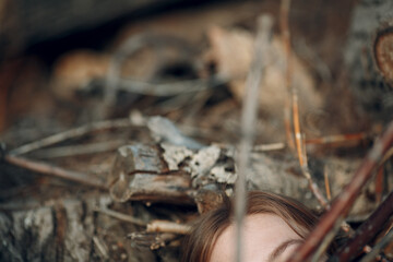 Teenager young woman lying outdoor in the park under dry tree branches. Sexual maniac crime rape violence concept