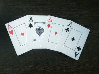 4 aces on a wooden table