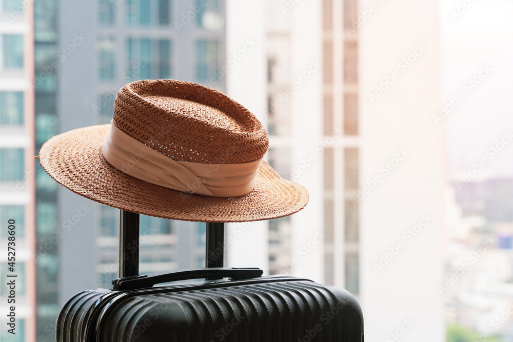 Wall mural suitcase and hat in hotel room. concept of travel and vacation