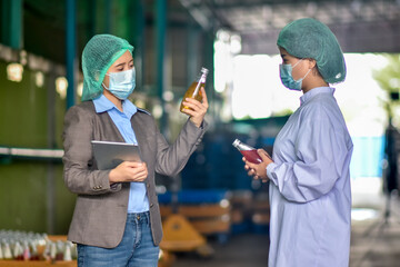 Beverage factory manager talking with operator for expiation work instruction