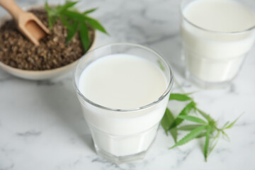Fototapeta na wymiar Hemp milk on white marble table, closeup