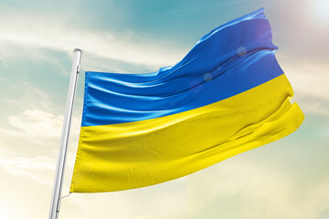 Ukraine national flag waving in beautiful clouds.