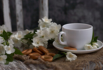 Obraz na płótnie Canvas Cup of tea with jasmine flowers on a vintage chair