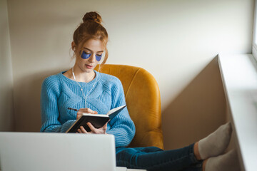 Ginger woman with freckles using laptop. Spa day at home and skin care procedures. Wearing eye...