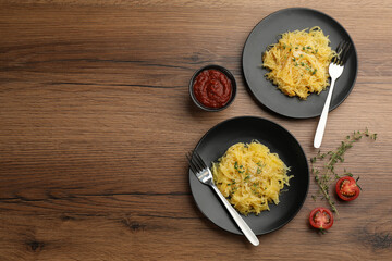 Tasty spaghetti squash with thyme and cheese served on wooden table, flat lay. Space for text
