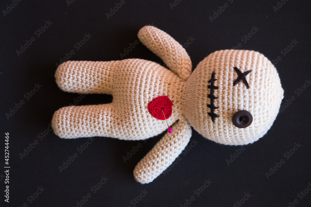 Wall mural voodoo doll lying on a black background.