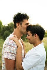 Fototapeta premium Happy young gay couple in love kissing with a sunset
