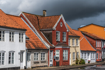 Fototapeta na wymiar Tonder, Denmark - August 10, 2021: beautiful old houses in a small street at a very rainy day