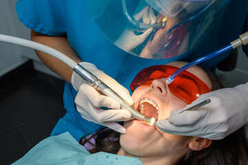 Process of removing dental braces from a Caucasian girl in a dental clinic with a female dentist