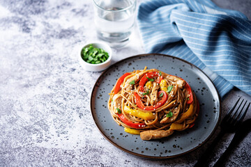Buckwheat pasta with chicken, mango and red pepper in a plate