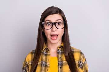 Photo of cute impressed young woman dressed checkered shirt glasses smiling open mouth isolated grey color background