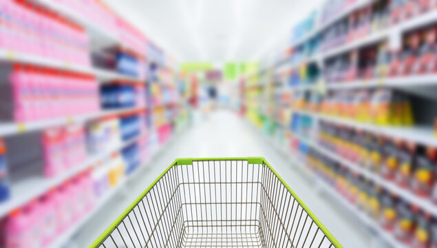 Shopping cart in blur supermarket background.