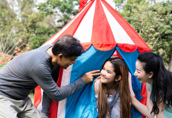 Happy young parents having fun camping and playing with their little girl in the backyard of their house, Our hobby. Lifestyle of family playing their happy life while enjoying being outdoors