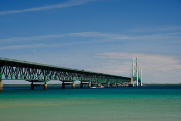 Obraz premium The colorful and clear waters of the straits of Mackinac and the Mackinac Bridge connecting the Upper and Lower Peninsula of Michigan