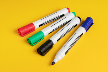 Color markers on yellow background. Close up