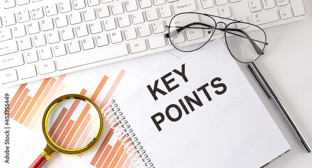 Poster key points text written on a notebook with keyboard, chart,and glasses