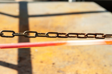 Metal chain on the background of sand and protective tape
