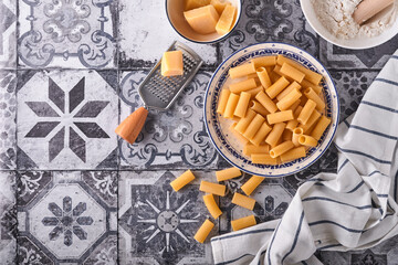 Pasta. italian pasta. Rigatoni and vegetables cooking ingredients on an old stone background. Italian food cooking ingredients. Top view with copy space.