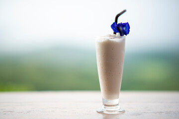 Vanilla Milkshake Smoothie in a Coffee Shop nature blur background.