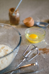 glass bowl with flour, cinnamon, egg with yolk and whisk