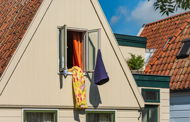 Colorful blanket hanging out of the window of the dutch house, bed linen ventilating