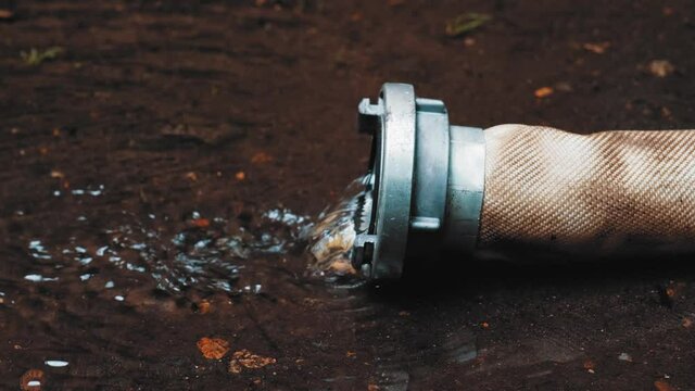 Clean Water Flowing Out of Polyester Fire Hose with Metal Aluminum Coupler