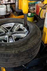Silver aluminum rim with a tire - chaning tires