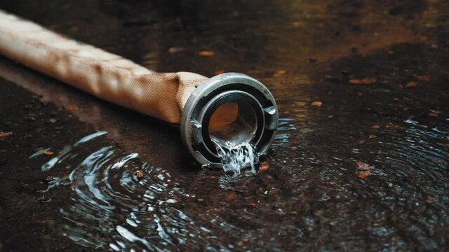 Clean Water Flowing Out of Polyester Fire Hose with Metal Aluminum Coupler