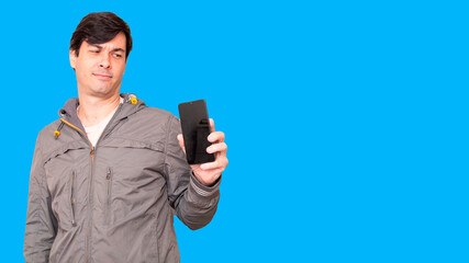 Man with doubt face looking at smartphone.