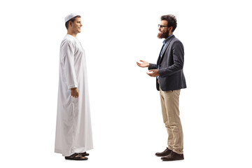 Full length profile shot of a young man in white ethnic clothes and a bearded man having a conversation