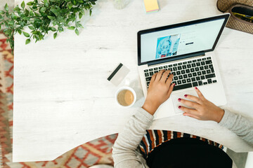 Woman browsing laptop during online shopping at home