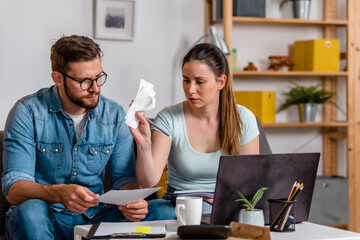 Obraz premium Young married couple is doing home budgeting. Financial problems
