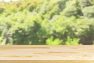 wood table top on blur tree and green foliage background