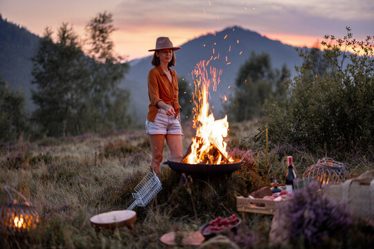 Woman at picnic with bonfire in the mountains