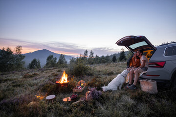 Couple by the fire at picnic in the mountains - 452768066