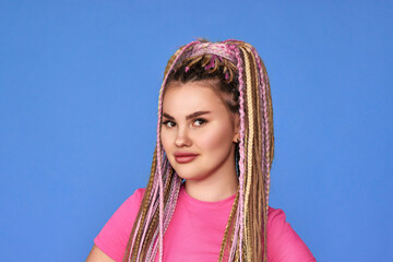 unsatisfied woman with dreadlocks on blue background.