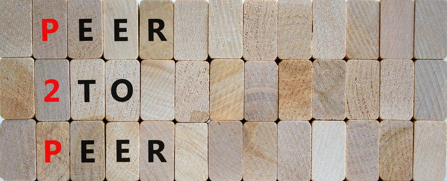 P2P, peer to peer symbol. Wooden blocks with concept words 'P2P, peer to peer'. Beautiful wooden background, copy space. Business and P2P, peer to peer concept.