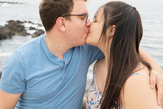 couple in love kissing each other while spending time outdoors on seaside